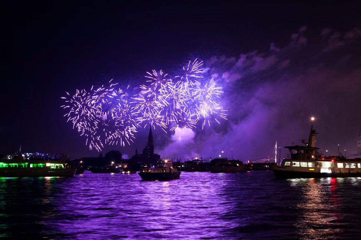 Violettes Feuerwerk über der Lagune von Venedig mit Booten im Vordergrund